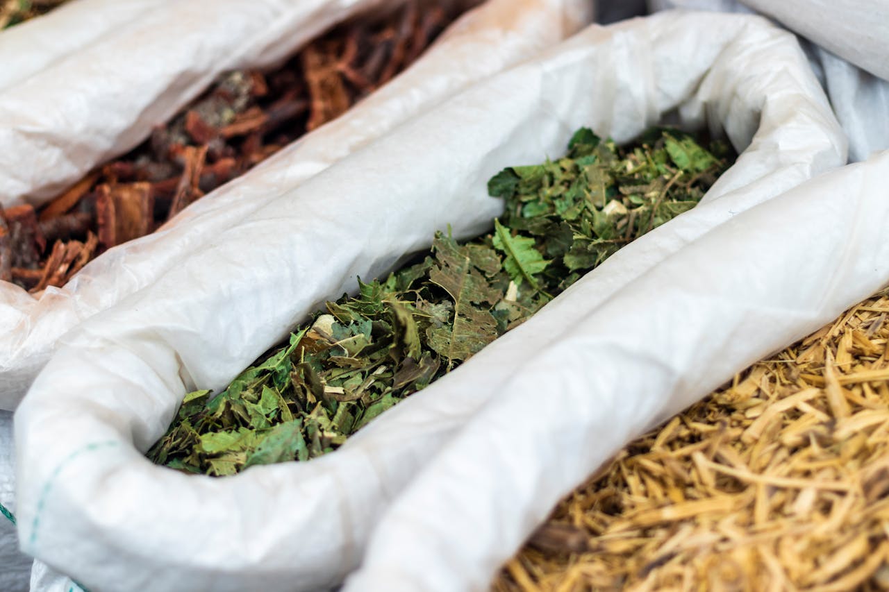 Close-up of assorted dried herbal leaves and bark in burlap sacks in São Paulo market.